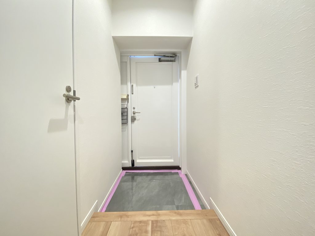 【玄関】 ホワイトで統一された玄関の様子です。シンプルでありながらも、床材のメープルの杢目が温かな印象を醸し出しています。
