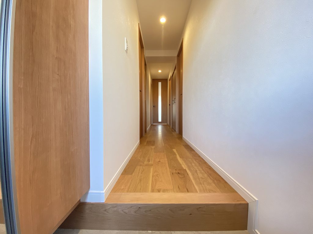 【室内廊下】 ブラックチェリーの床材と白いクロスがすっきりと明るい印象。大型のシューズボックスが付いています。