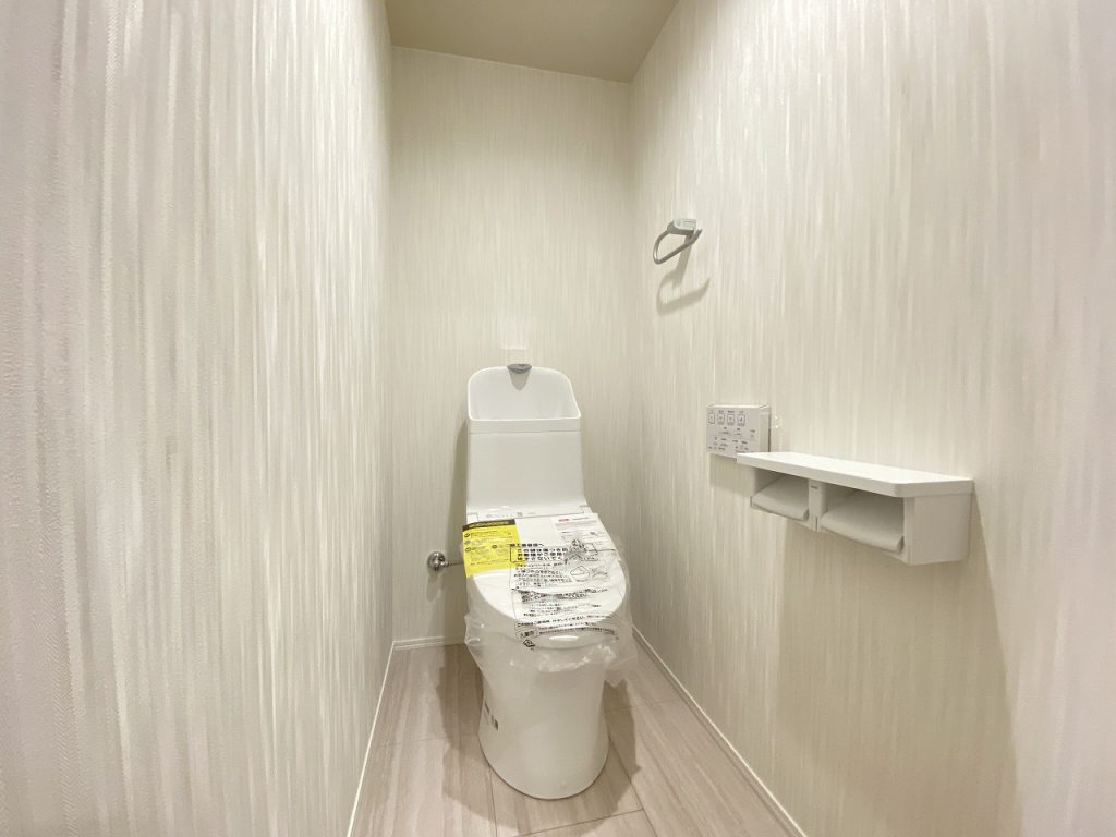 【トイレ】 清潔感のあるトイレはウォシュレト一体型になっています。美しい模様のクロスが上品な印象です。