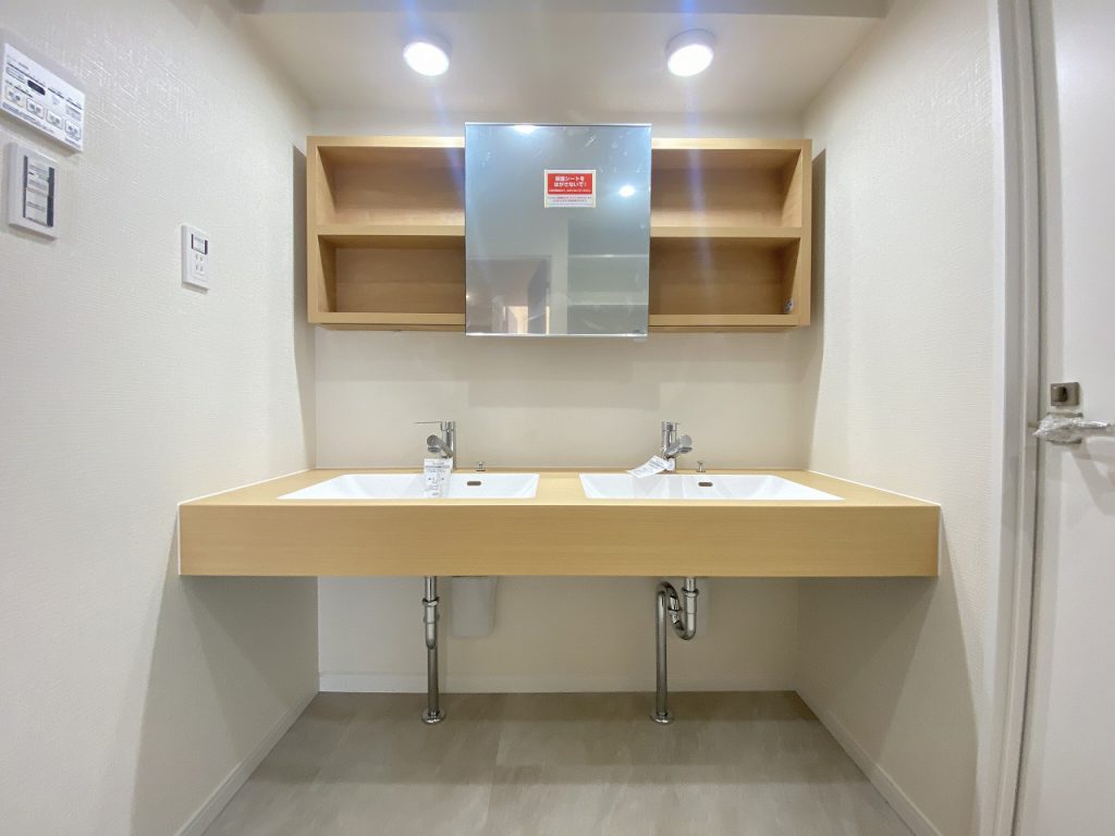 【洗面室】 4LDKのライフスタイルに合わせた広い洗面室。洗面化粧台はダブル洗面ボウル仕様になっています。鏡の後ろにも大型の収納を設置。ホテルのようなスタイリッシュなデザインになっています。