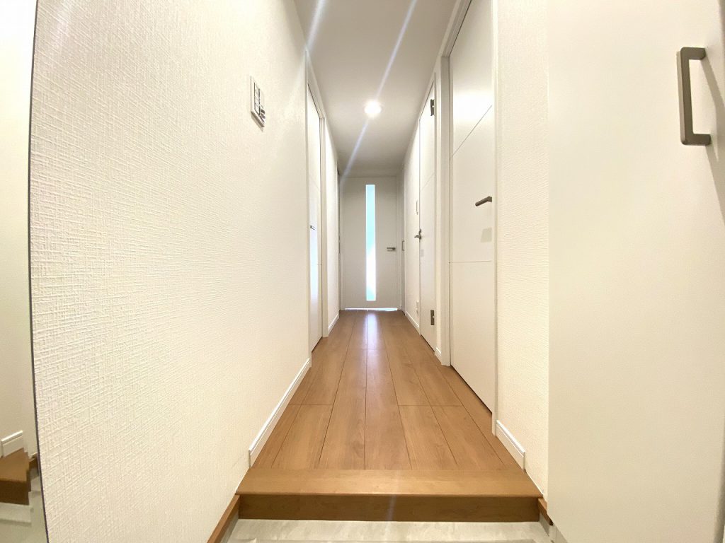 【室内廊下】玄関からリビングに続く室内廊下部分の様子です。ホワイトを基調とした爽やかなデザインに仕上げています。