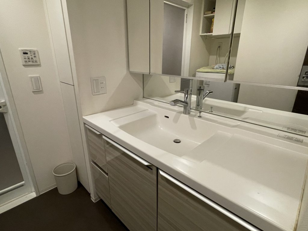 【洗面室】広い洗面ボウルと収納が付いた洗面化粧台の様子です。鏡は三面鏡仕様になっています。