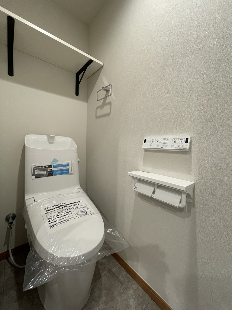 【トイレ】 清潔感のあるトイレはウォシュレット一体型になっています。棚板付きのオープン収納があるのでトイレットペーパー等のストックを収納していただけます。