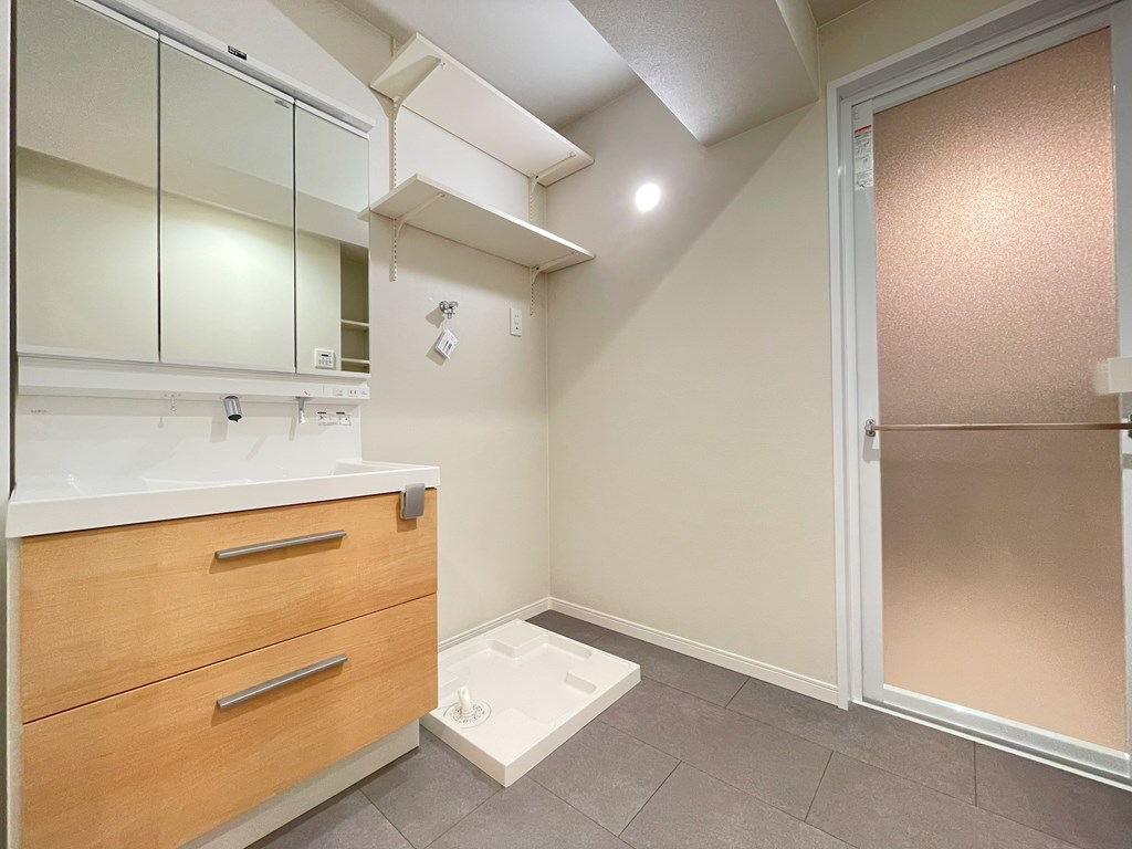 【洗面室】 収納付の洗面化粧台完備。室内洗濯機置場も洗面室にあります。洗濯機置場の上部にも収納棚がついています。リネン類や洗剤のストックを置いていただけます。