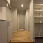【室内廊下】 玄関からリビングにつながる室内廊下の様子です。建具はグレイッシュトーンを基調として優しい印象の空間を感じていただけます。