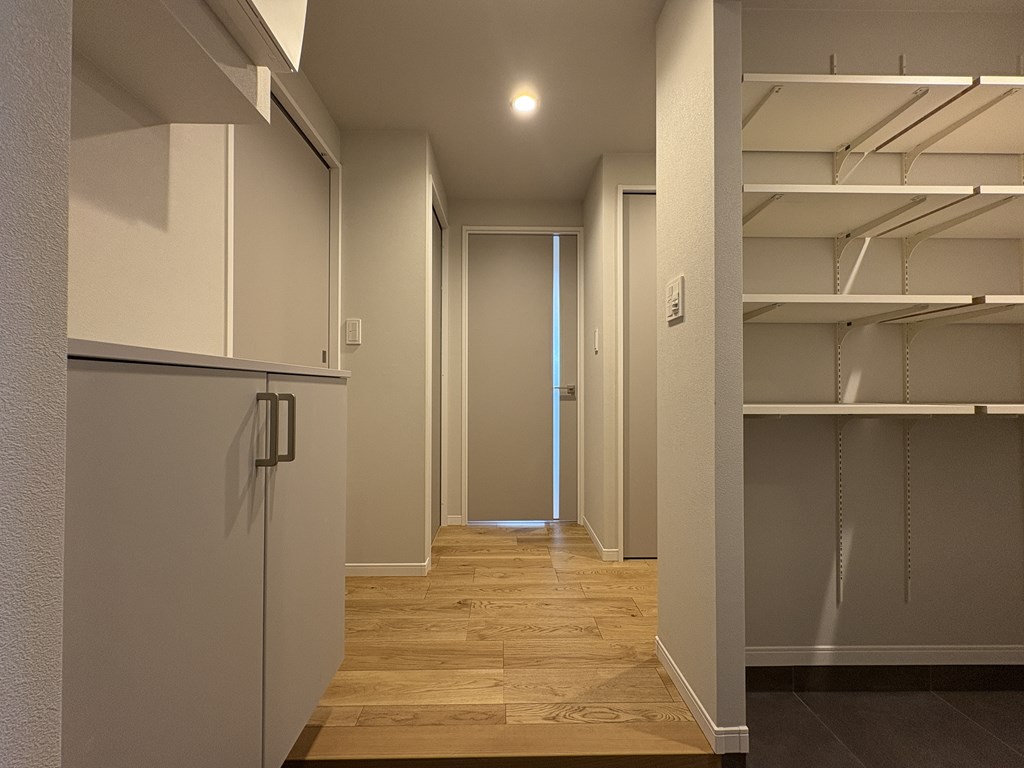 【室内廊下】 玄関からリビングにつながる室内廊下の様子です。建具はグレイッシュトーンを基調として優しい印象の空間を感じていただけます。