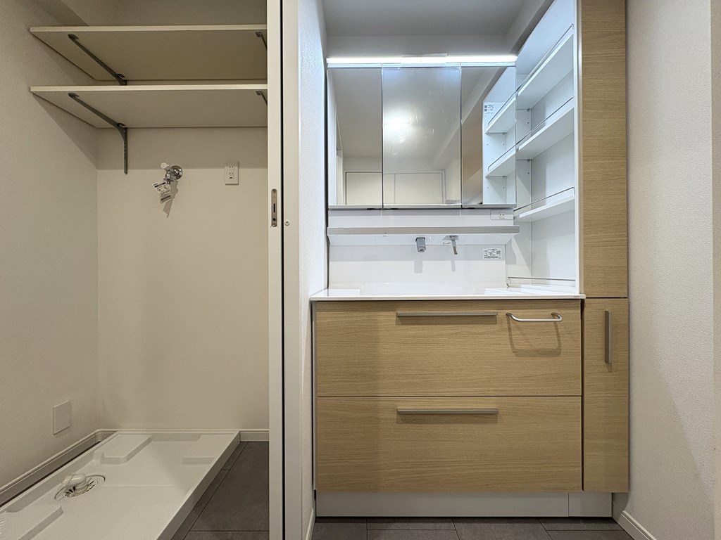 【洗面化粧台】 収納付の洗面化粧台。洗面室と脱衣室は引き戸で分離できる間取りです。脱衣室には室内洗濯機置場、造作のカウンターが設けられています。