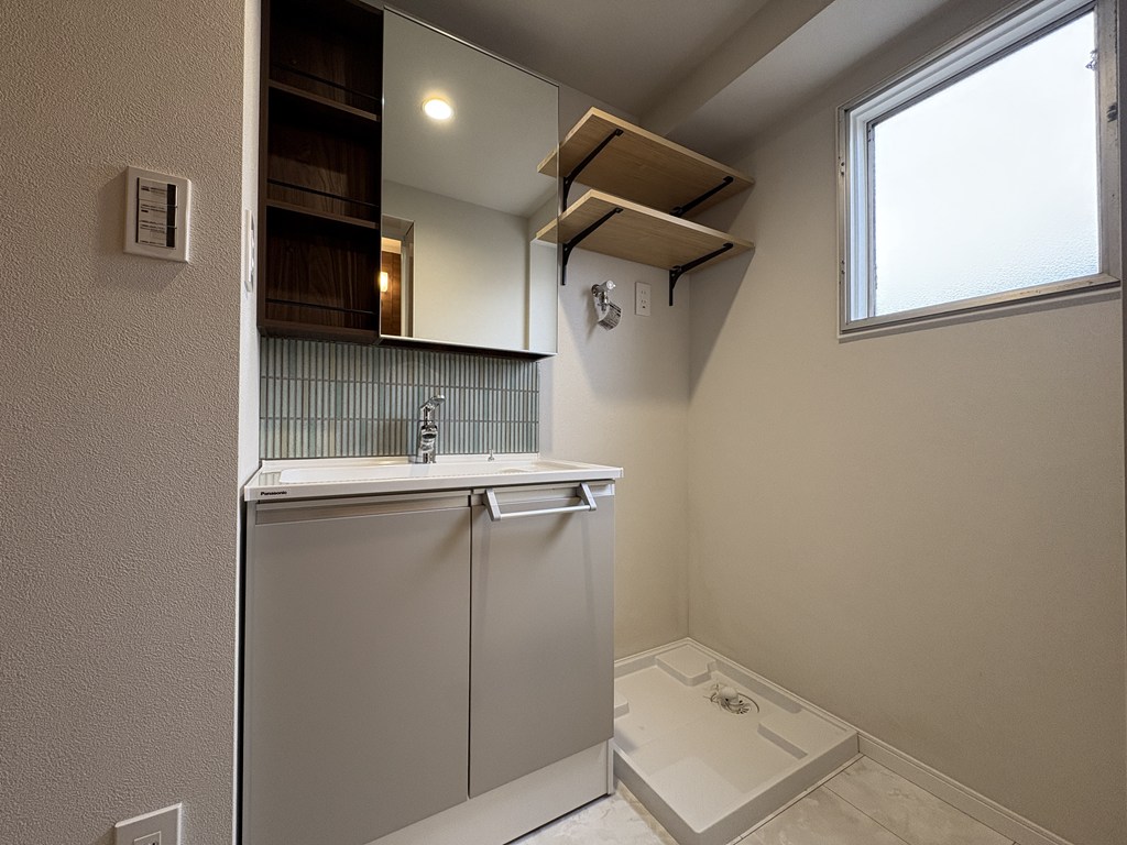 【洗面室】 洗面室の様子です。室内洗濯機置場の上部にも収納完備。洗面室にも窓があります。
